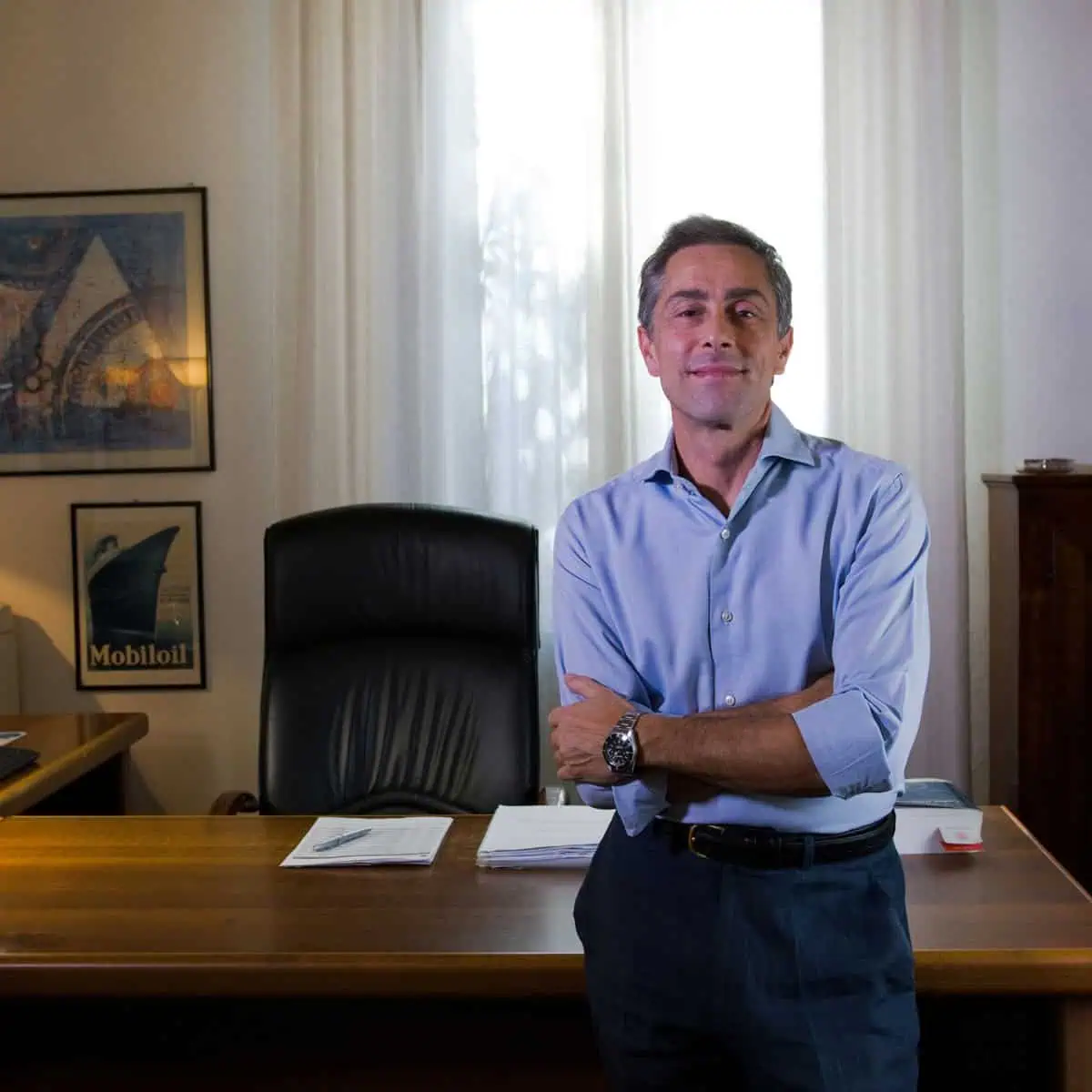 Dottor Reverberi Andrea appoggiato alla scrivania, sorride al visitatore